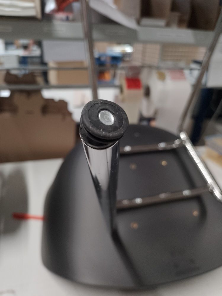Detailaufnahme vom Fuß eines schwarzen About A Chair AAC26 Stuhls mit Chromgestell, Mängelexemplar.