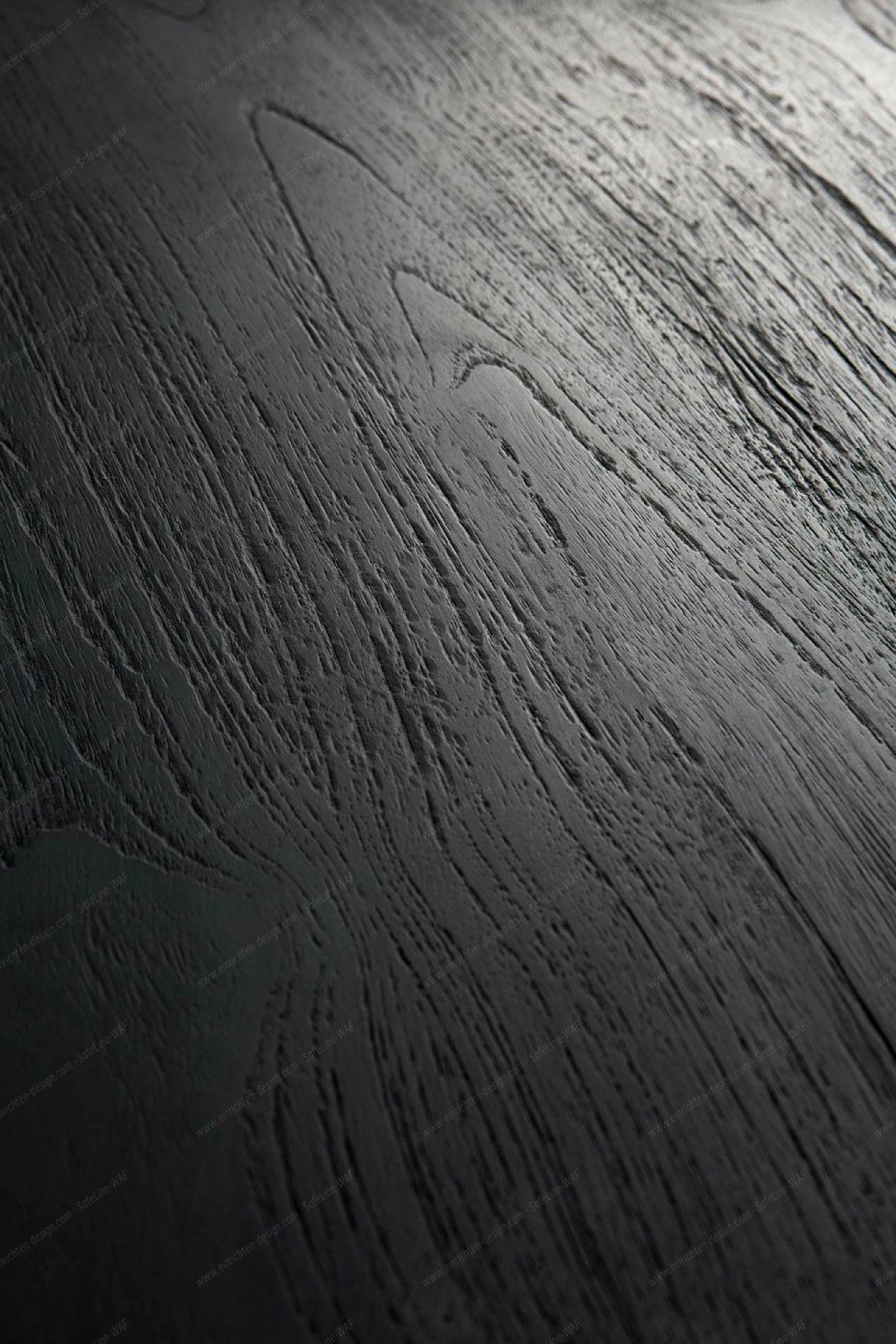 Detailaufnahme der schwarzen Eichenholz-Tischplatte des Tripod Beistelltisches von Ethnicraft, Fokus auf die markante Holzmaserung.