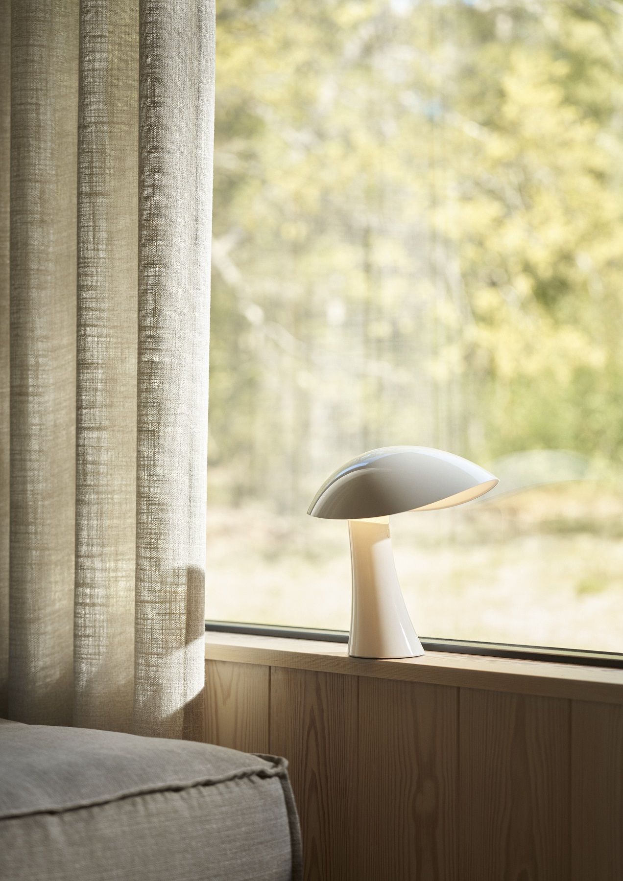Nahaufnahme der Rumee Akkuleuchte von Louis Poulsen auf einer Fensterbank, modernes Design.