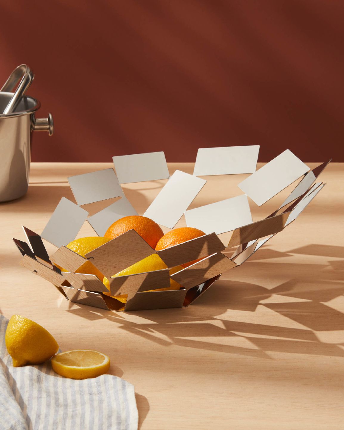 Alessi La Stanza Dello Scirocco Tafelaufsatz mit Zitronen und Orangen auf einem Holztisch.