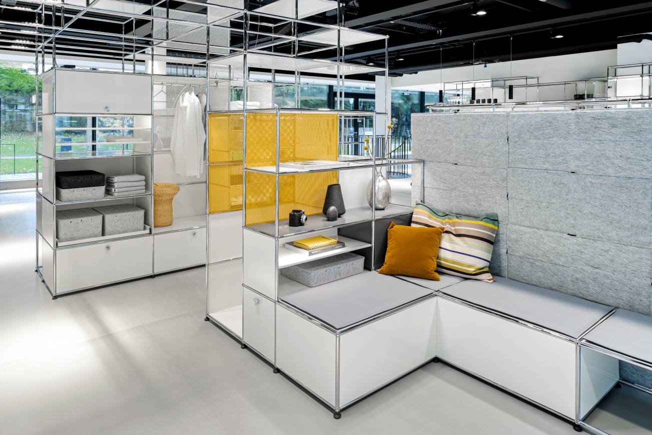 USM Haller Möbel mit Privacy Panels in Weiß und Gelb, modulare Regale und Sitzbank.