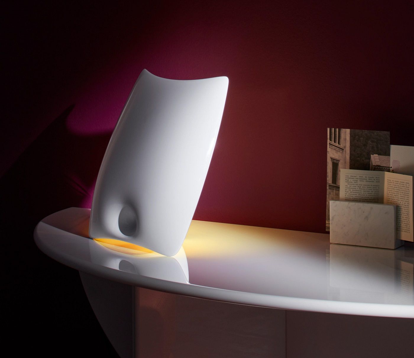 Valor.S Tischleuchte Keramik Cassina Gold auf einem Tisch, abstraktes Design mit warmem Lichtschein.