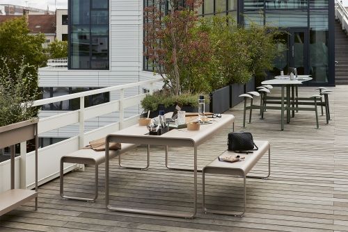Fermob Bolder Outdoor Tischgruppe mit Sitzbänken auf einer Dachterrasse, ideal für den Garten.