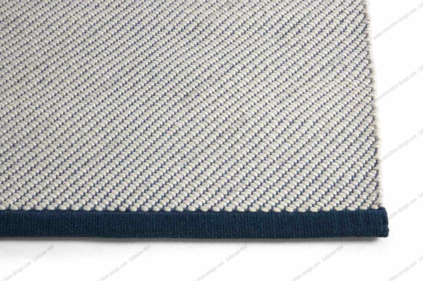 Detailansicht des Bias Rug Tint Teppichs in Ocean Tint: Hochwertiger Teppich mit blauem Rand.