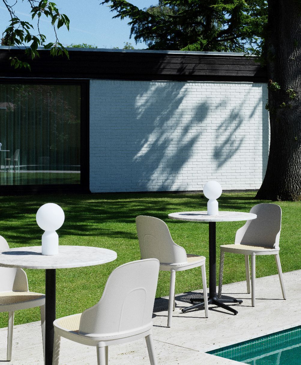 Yo Lamp Small Tischleuchte von Normann Copenhagen im Garten auf einem runden Tisch.