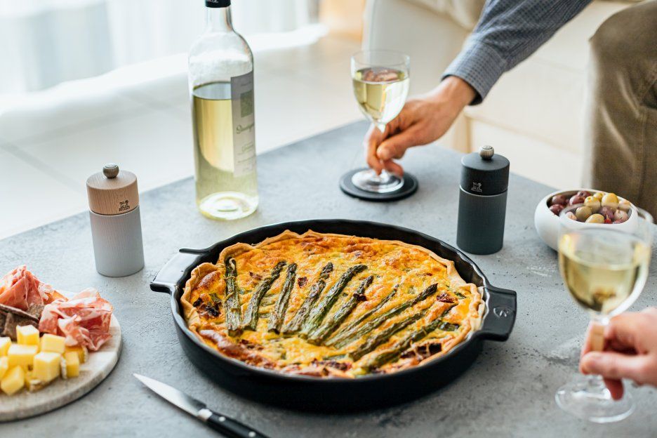 Produktfoto: Peugeot Line Salzmühle aus Aluminium und Naturholz neben Quiche, Wein und Antipasti.