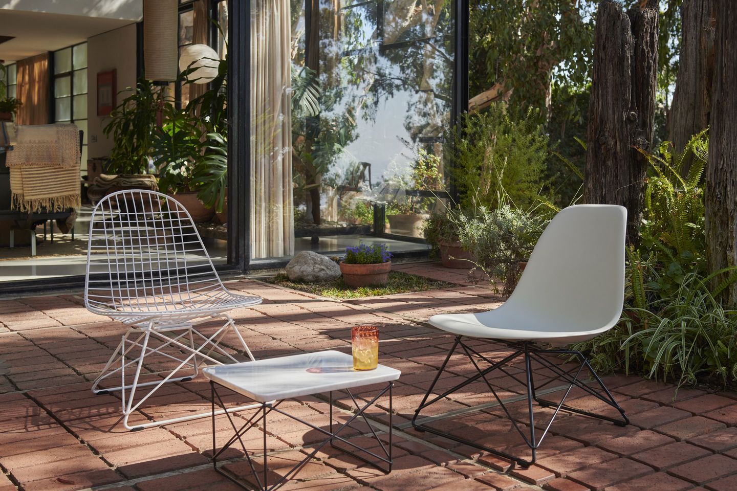 Vitra LKR-2 Wire Chair Stuhl und Eames Plastic Chair im Garten mit Beistelltisch.