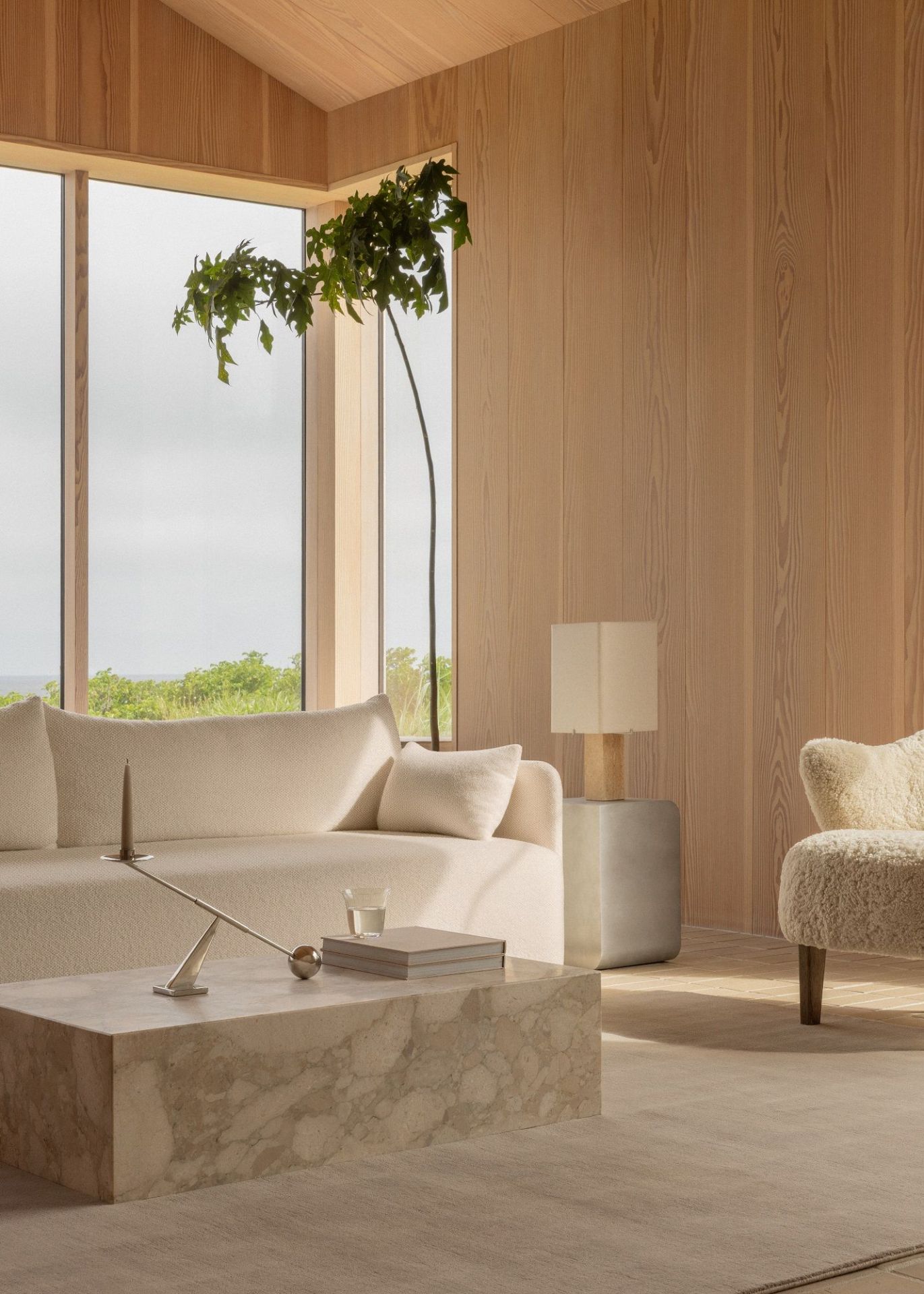 Heller Wohnraum mit Audo Copenhagen Beistelltisch, Lampe und Couch in sanften Naturtönen.