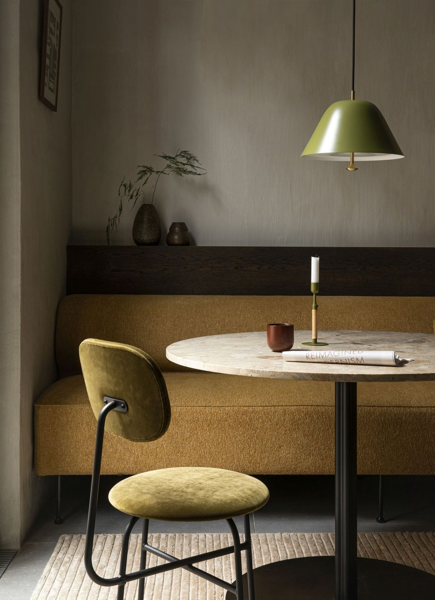 Audo Copenhagen Afteroom Stuhl in Olivgrün am Esstisch mit Bank und Pendelleuchte.