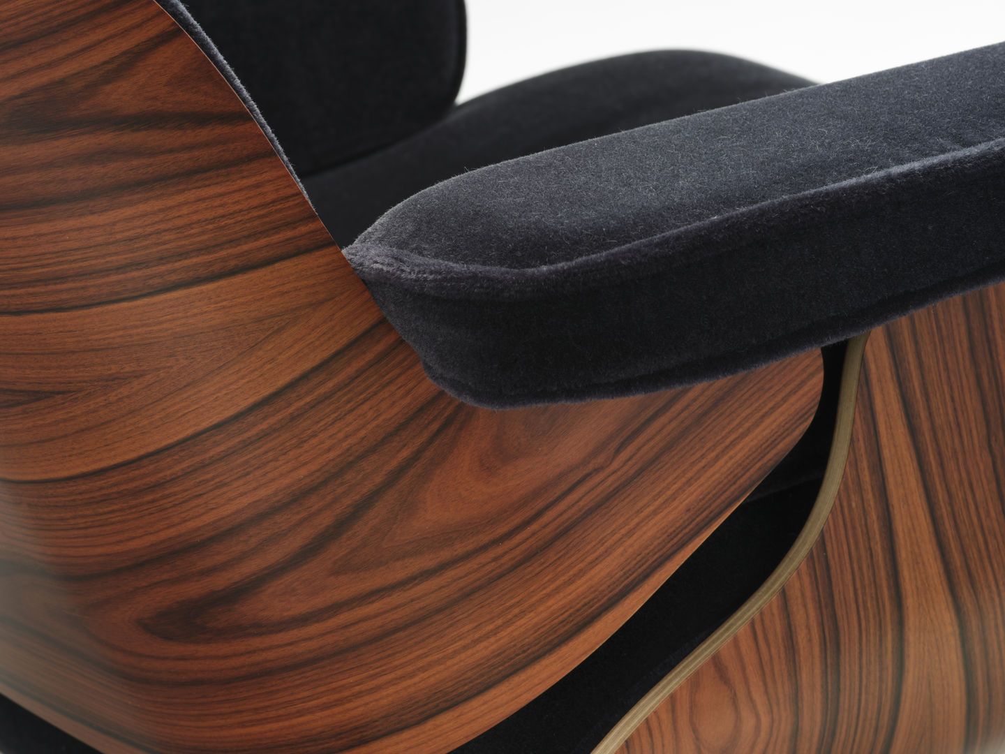 Detailaufnahme des Eames Lounge Chair Sessels von Vitra mit dunklem Bezug und Holzschale.