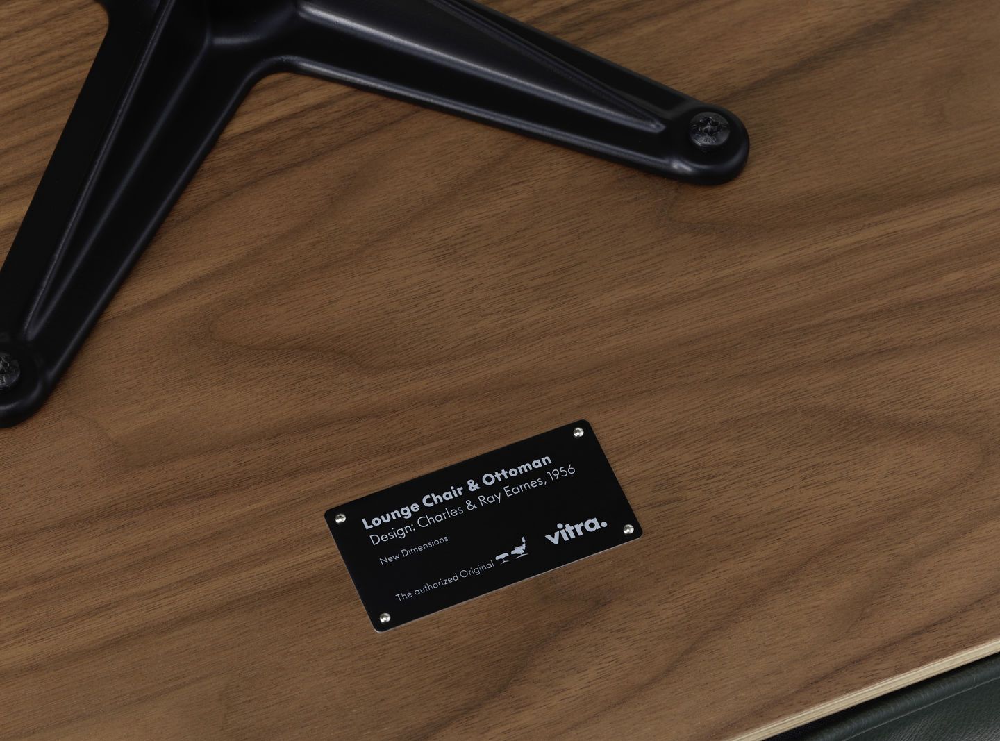 Detailaufnahme Eames Lounge Chair & Ottoman von Vitra, Fokus auf Holzstruktur und Herstellerplakette.