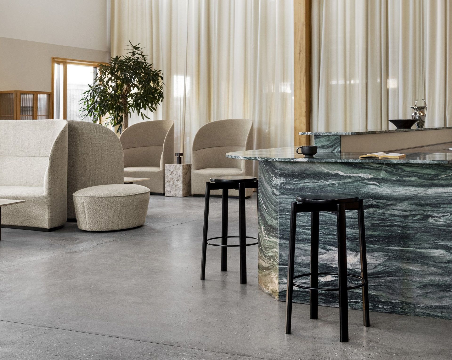 Passage Bar Stool von Audo Copenhagen aus schwarzem Holz vor einer grünen Marmorbar.