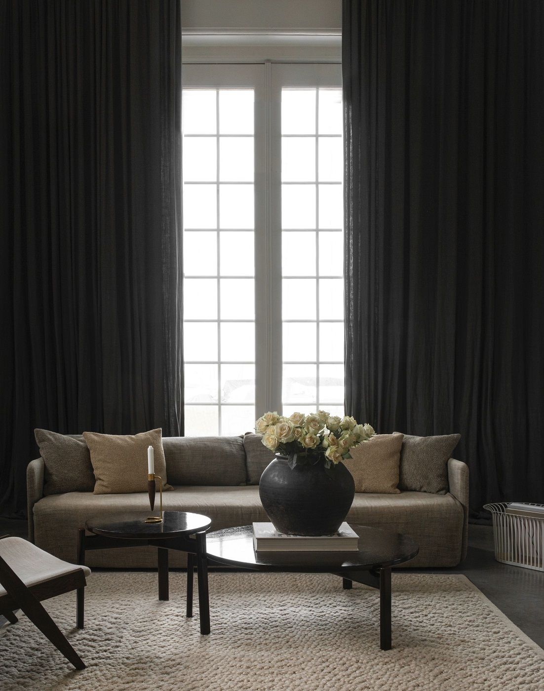 Beiger Gravel Rug Teppich von Audo Copenhagen in einem stilvollen Wohnzimmer mit Sofa und Tisch.