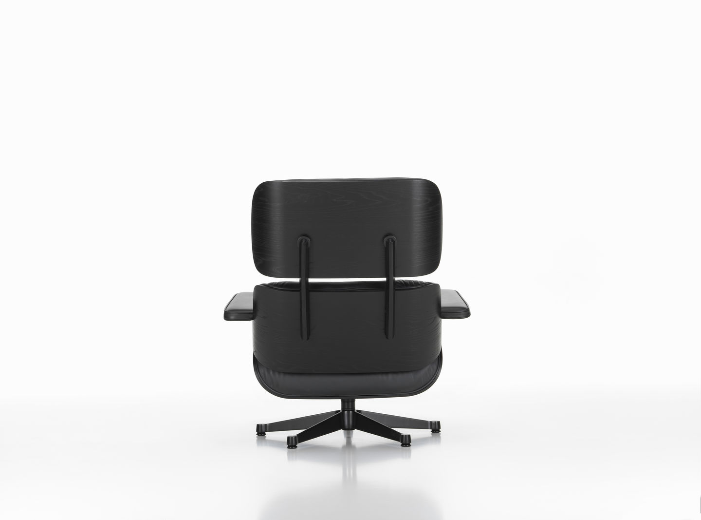 Rückansicht des schwarzen Eames Lounge Chair Sessels mit Ottoman von Vitra auf weißem Hintergrund.