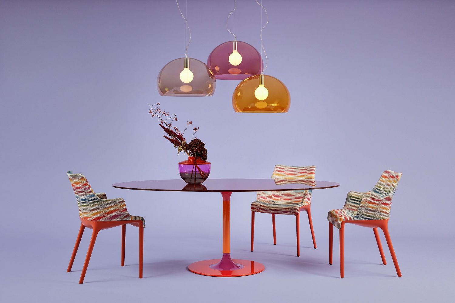 Big Fly FL/Y Pendelleuchten von Kartell in Braun, Lila und Orange über Esstisch mit Stühlen.