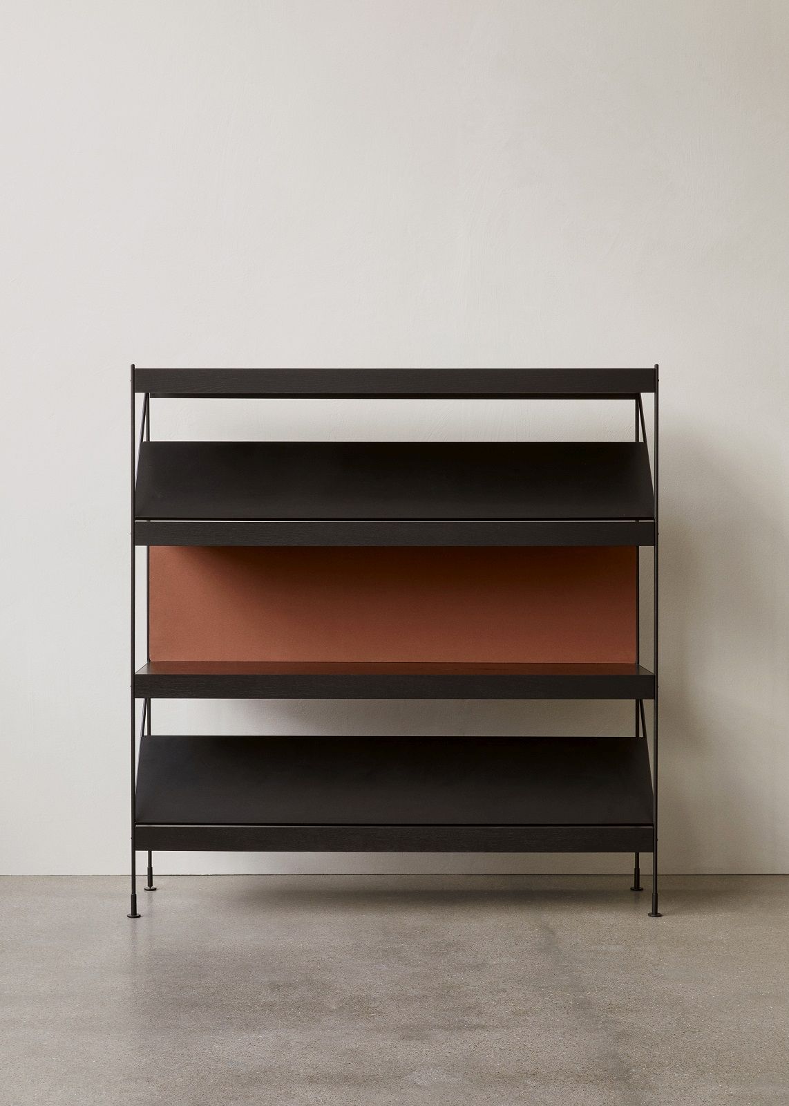 Schwarzes Audo Copenhagen Zet Storage System Regal mit drei Ebenen und kupferfarbener Rückwand.
