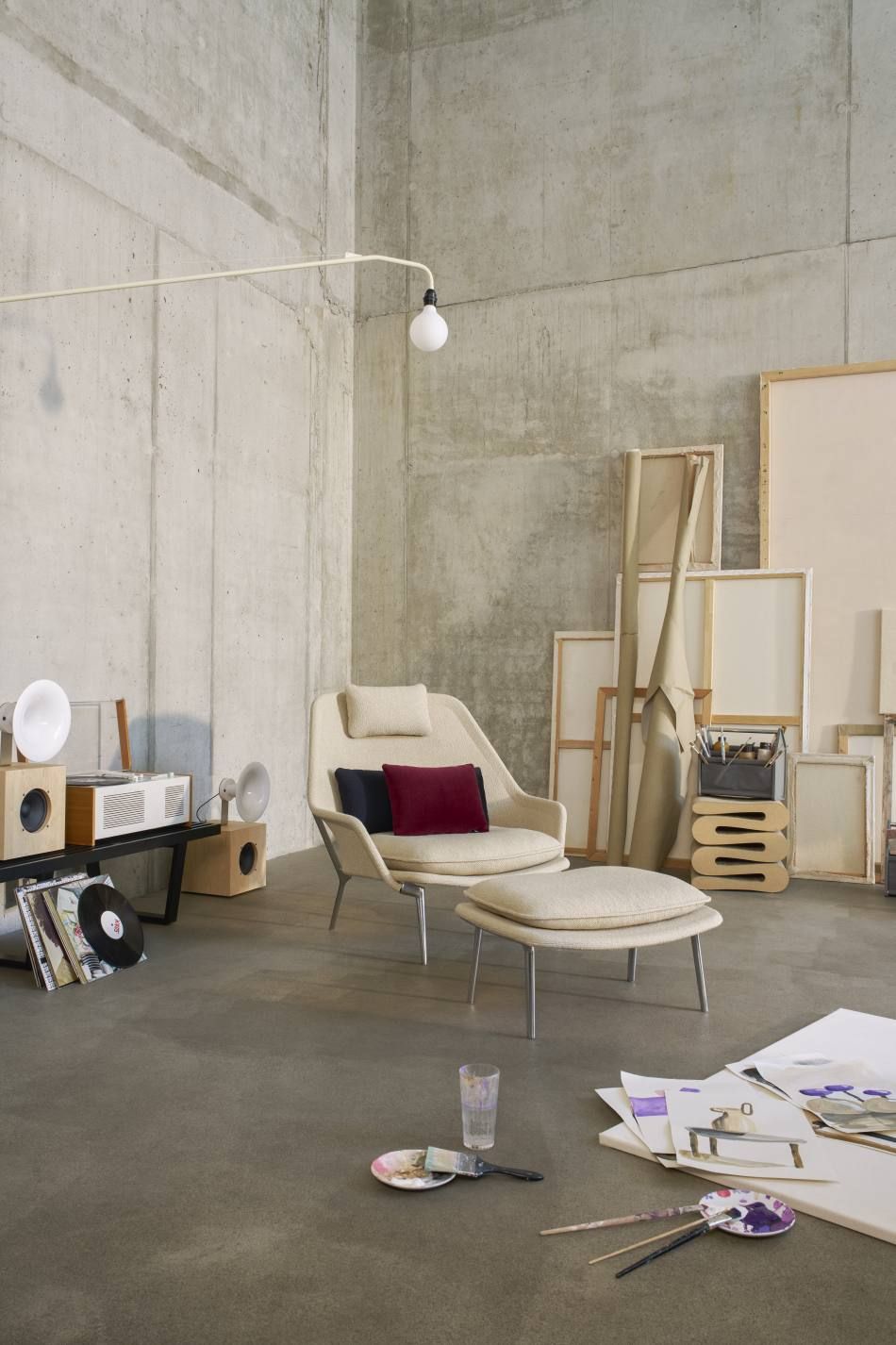 Vitra Slow Chair Sessel mit Hocker, Stoffbezug in Beige, Kissen in Rot und Schwarz.